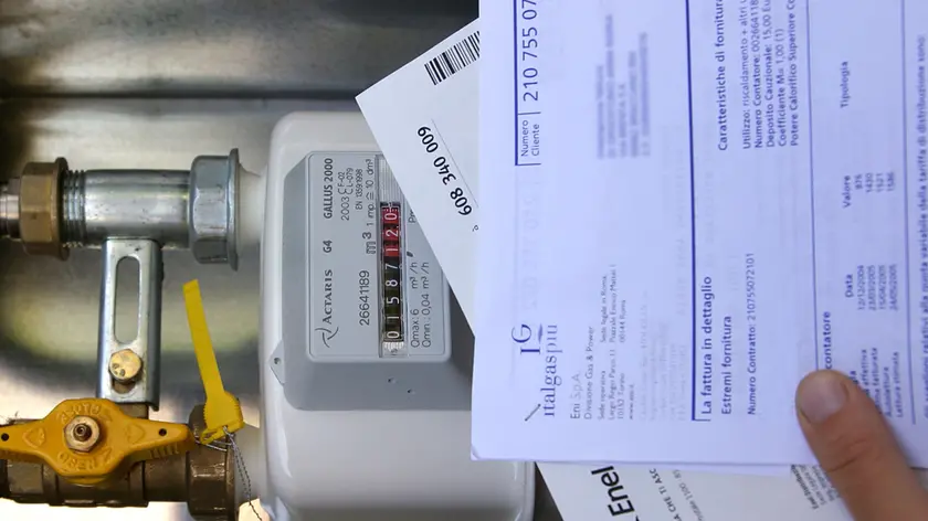 Un utente controlla una fattura vicino ad un contatore