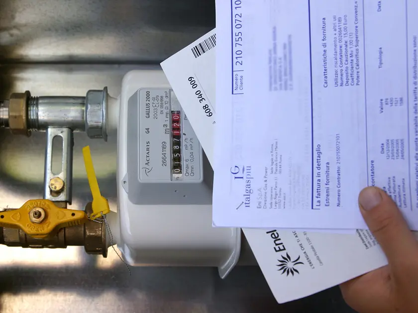 Un utente controlla una fattura vicino ad un contatore