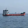 Un mercantile attraversa lo stretto di Hormuz. Sotto il terminal container nel porto di Venezia