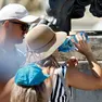 Turisti cercano refrigerio dal caldo a una fontanella (foto Ansa)