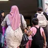 Una mamma musulmana mentre accompagna il figlio ascuola