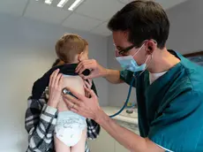 Un pediatra visita un piccolo paziente