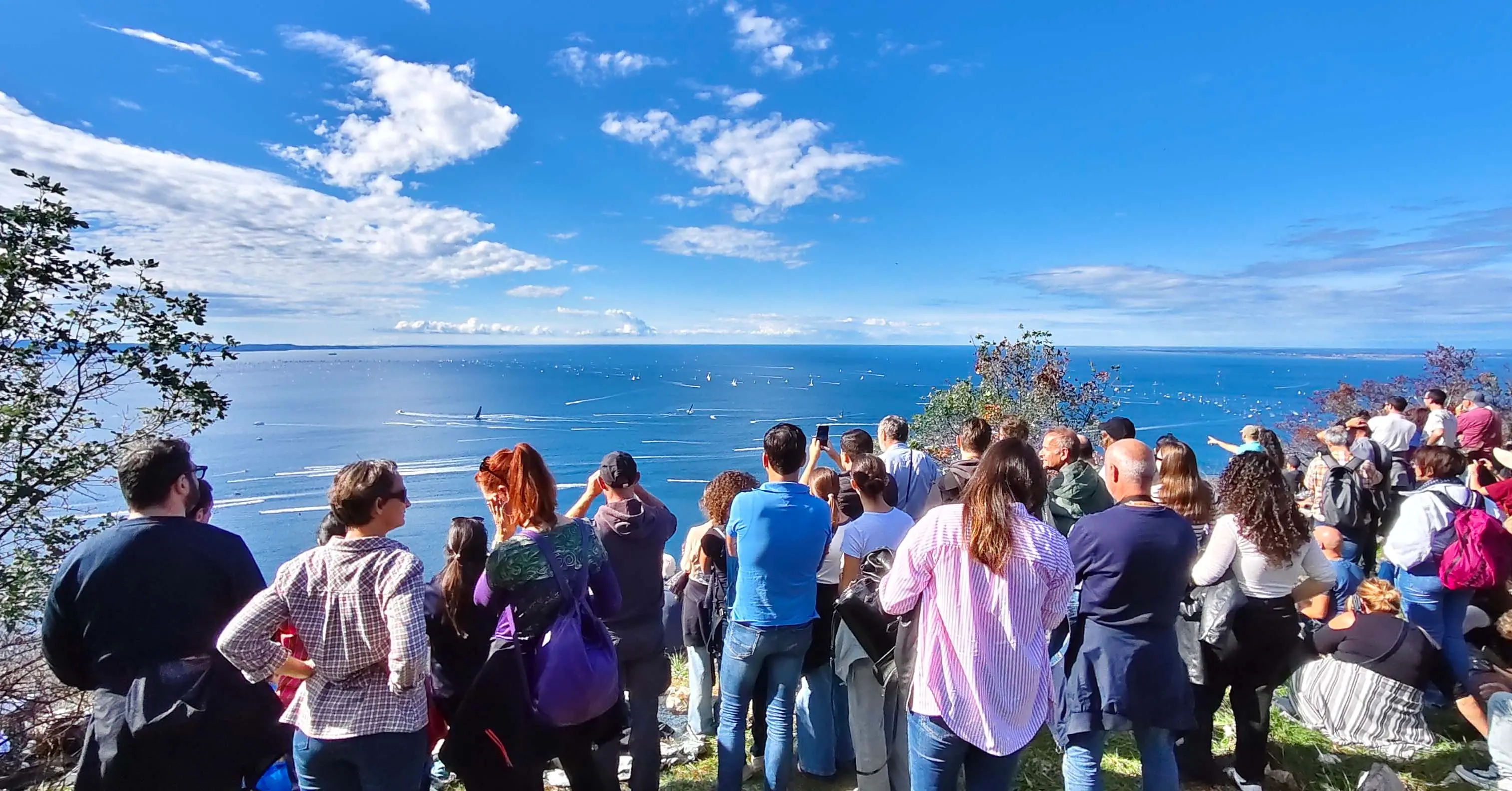 Mentre in mare imperversava la sfida tra le 1.858 barche iscritte alla Barcolana, migliaia di persone si sono godute lo spettacolo da terra: dal Castello di San Giusto al Carso triestini e turisti hanno preso d'assalto tutti i punti di osservazione. Le foto sono di Andrea Lasorte e Francesco Bruni