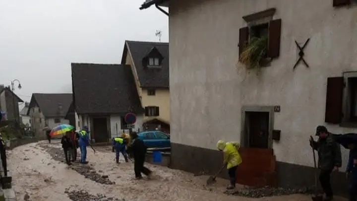 Al lavoro per spalare via il fango durante la tempesta vaia