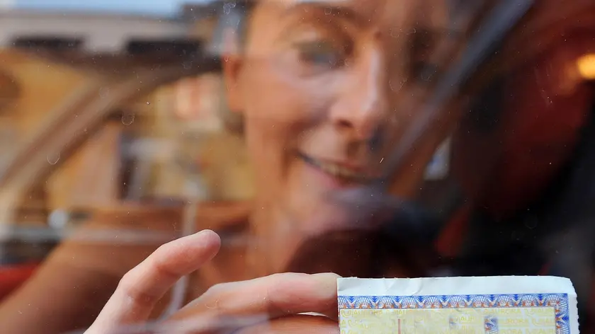 Una ragazza sistema il contrassegno dell'assicurazione sul parabbrezza dell'auto. Una riduzione del premio medio delle assicurazioni rc auto del 11,8% negli ultimi 5 anni ''piacerebbe molto anche a noi, e sopratutto a tutte le famiglie italiane'', ma ''purtroppo la realta' e' ben lontana''. Cosi' Federconsumatori e Adusbef commentano i dati contenuti nel rapporto dell'Ania, presentato oggi in occasione dell'assemblea annuale dell'associazione. Secondo l'Osservatorio Federconsumatori, infatti, ''le tariffe, dal 1994 ad oggi, hanno registrato una crescita del 173%, e rispetto allo scorso annodel 18%'' . ANSA/CLAUDIO ONORATI/on.