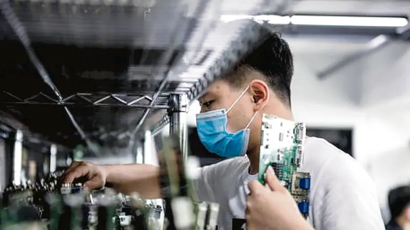 epa08296711 A man works in the VDWALL factory in Shenzhen, Guangdong province, China, 13 March 2020 (issued 16 March 2020). China's value-added industrial output, an important economic indicator, fell 13.5 percent year-on-year in the first two months of 2020 as the coronavirus outbreak hurt activities, according to a report issued by the National Bureau of Statistics on 16 March 2020. VDWALL is a high-tech enterprise specializing in developing and manufacturing video processing equipment for LED displays. EPA/ALEX PLAVEVSKI