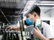 epa08296711 A man works in the VDWALL factory in Shenzhen, Guangdong province, China, 13 March 2020 (issued 16 March 2020). China's value-added industrial output, an important economic indicator, fell 13.5 percent year-on-year in the first two months of 2020 as the coronavirus outbreak hurt activities, according to a report issued by the National Bureau of Statistics on 16 March 2020. VDWALL is a high-tech enterprise specializing in developing and manufacturing video processing equipment for LED displays. EPA/ALEX PLAVEVSKI