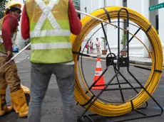 Singapore, Republic of Singapore, Asia - Two workers are laying cables on a road in the central business district.