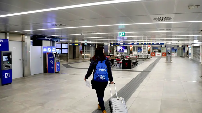 One of the last departing passengers walks inside Milan's Linate cityairport which is semi-deserted due to the coronavirus emergency, MIlan, Italy, 13 March 2020. One of the last departing passengers walks inside Milan's Linate airport which is semi-deserted due to the coronavirus emergency. the entire Milan Linate airport was temporarily closed. In order to minimize the number of people involved in operational activities to protect the health of all and according to the provisions of the Decree issued today by the Ministry of Transport, commercial and general aviation passenger traffic will be concentrated on Milan Malpensa airport. ANSA/Mourad Balti Touati