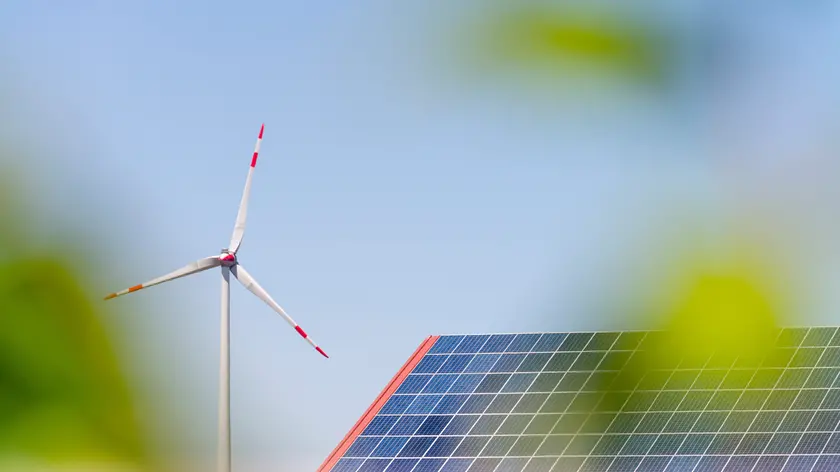 Solar systems and wind turbine in the cornfield under blue sky with plant
