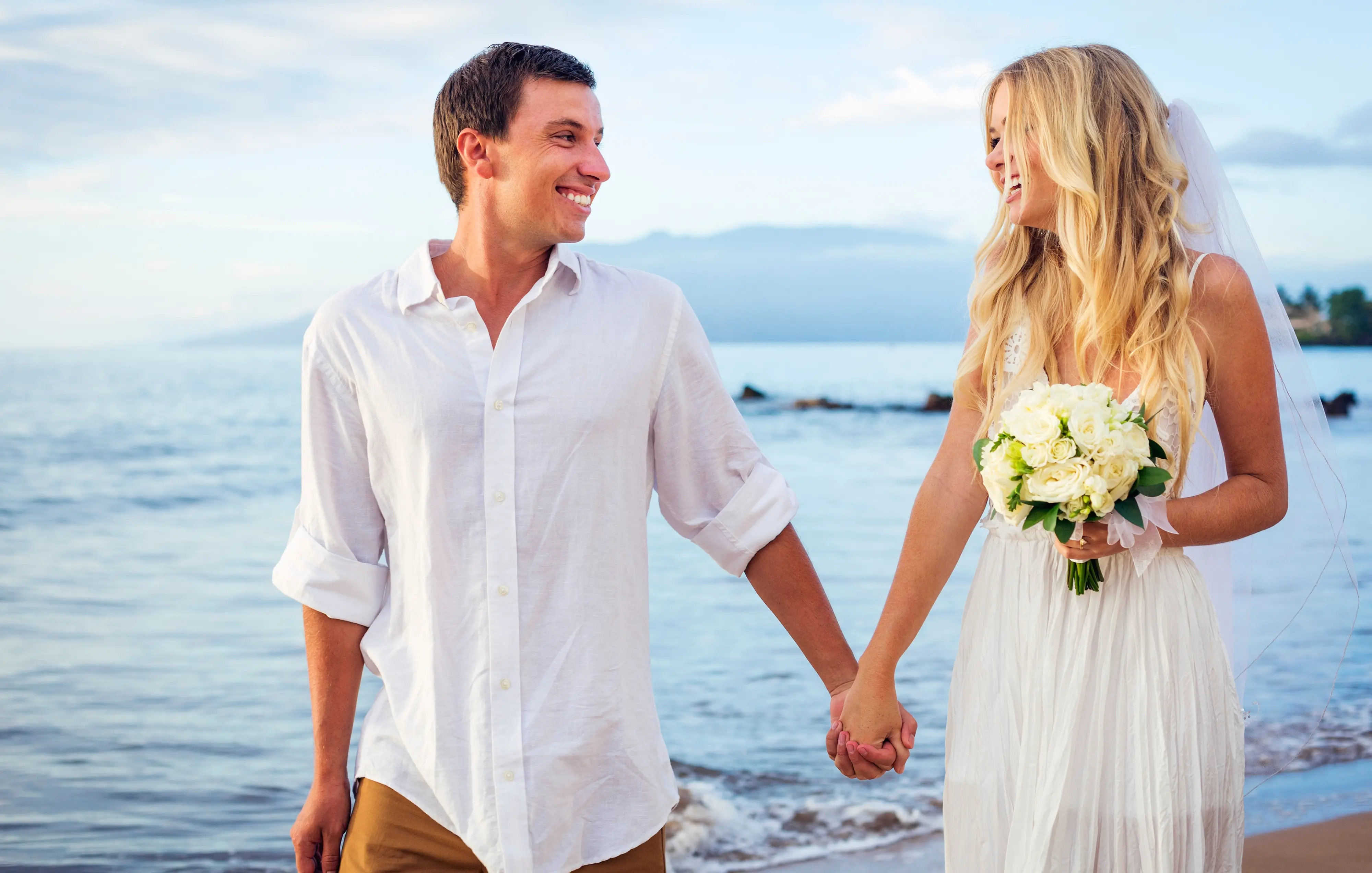 A married couple, bride and groom, at sunset on a beautiful tropical beach