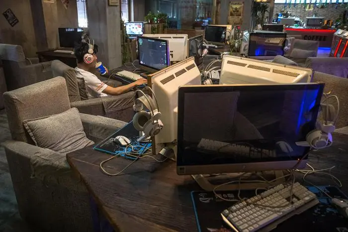 epa06000638 A Chinese man uses a computer at an internet cafe in Beijing, China, 31 May 2017. China will adopt a controversial cybersecurity law from 01 June despite concerns from overseas groups doing business in China. The aim of the law is to protect networks and private user information with rigorous data surveillance and storage for companies and firms working in China. EPA/ROMAN PILIPEY