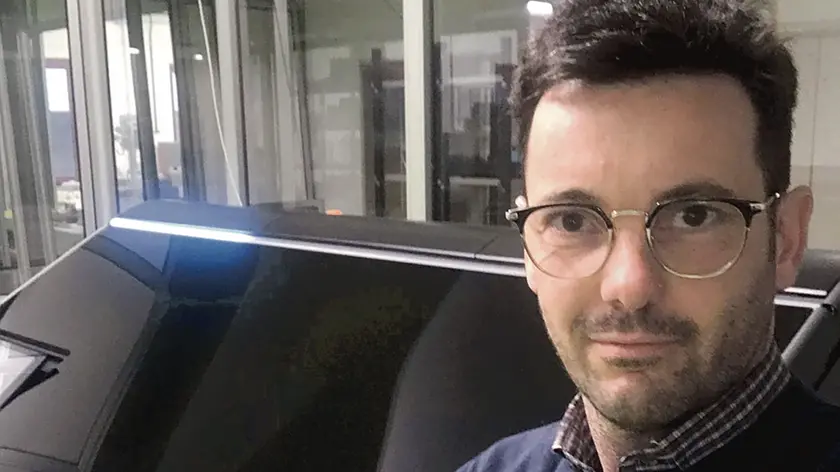 Andrea Cruzzola mostra alle sue spalle la stampante in 3D