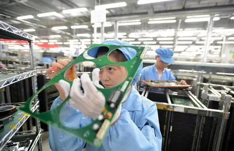 epa04863628 A picture made available on 28 July 2015 of woman works on the production line at FiberHome Technologies Group in Wuhan , Hubei province, central China, 27 July 2015. The Caixin-Markit China flash manufacturing PMI report, released July 24, says the index fell to 48.2, down from 49.4 in June. EPA/SHEPHERD ZHOU CHINA OUT