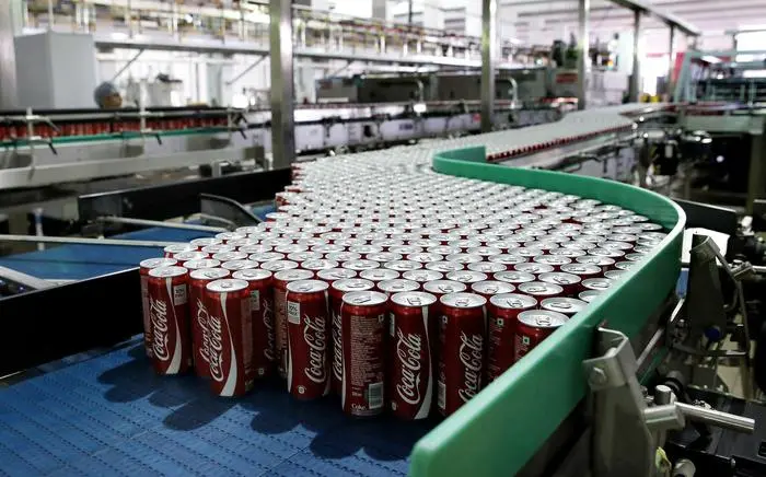 epa03833340 Coca Cola cans on a line at the new Coca-Cola bottling facility, after it was inaugurated by Executive Vice President and President of Coca-Cola International Ahmet C. Bozer, in Greater Noida in Uttar Pradesh, India, 22 August 2013. The new plant is owned and operated by franchise partner Moon Beverages and has two lines: a can line to manufacture sparkling beverages and a still beverage line. EPA/HARISH TYAGI