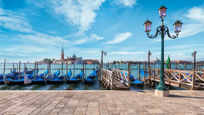 Gondolas of Venice in Riva degli Schiavoni with St. George's island in the background, Venice, Veneto, Italy.