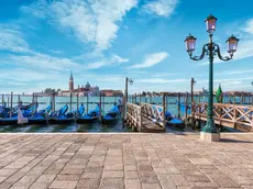 Gondolas of Venice in Riva degli Schiavoni with St. George's island in the background, Venice, Veneto, Italy.