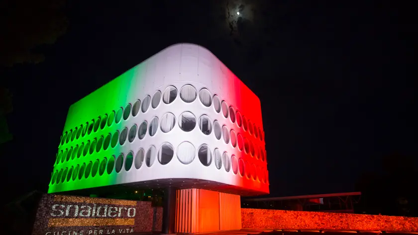 Il tricolore illumina la facciata della sede Snaidero a Majano Majano, 3 Maggio 2020 - Domenica 3 maggio, il tricolore ha illuminato la storica sede di Snaidero a Majano (Udine). L’iconico palazzo Snaidero, disegnato dall’architetto Mangiarotti negli anni Settanta, è il simbolo dell’azienda friulana che da 74 anni produce cucine per il mercato italiano e internazionale e che oggi rappresenta una delle più fiorenti realtà industriali del nord Italia. Con l’illuminazione della sede attraverso i colori della bandiera italiana, Snaidero vuole lanciare un messaggio di solidarietà e speranza al territorio e a tutti i collaboratori del Gruppo. @credits Foto: Ranieri Furlan Fotografo Illuminazione: Lighting Design by GP Eventi di Gerry Paredes Video: Creavidea di Romano Urbani Intervista: Pomarè Alessandro