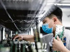 epa08296711 A man works in the VDWALL factory in Shenzhen, Guangdong province, China, 13 March 2020 (issued 16 March 2020). China's value-added industrial output, an important economic indicator, fell 13.5 percent year-on-year in the first two months of 2020 as the coronavirus outbreak hurt activities, according to a report issued by the National Bureau of Statistics on 16 March 2020. VDWALL is a high-tech enterprise specializing in developing and manufacturing video processing equipment for LED displays. EPA/ALEX PLAVEVSKI