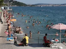 La spiaggia di Barcola presa d’assalto ieri dai bagnanti per combattere l’afa nonostante i 30 gradi del mare Foto Andrea Lasorte