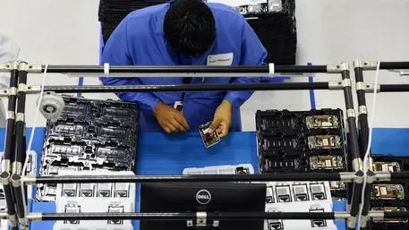 epa03861218 Factory workers assemble phones on the factory floor during the opening of the new Motorola Flextronics factory in Fort Worth, Texas, USA, 10 September 2013. The new Moto X smartphone will be assembled at the factory in Fort Worth. EPA/LARRY W. SMITH