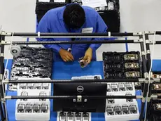 epa03861218 Factory workers assemble phones on the factory floor during the opening of the new Motorola Flextronics factory in Fort Worth, Texas, USA, 10 September 2013. The new Moto X smartphone will be assembled at the factory in Fort Worth. EPA/LARRY W. SMITH