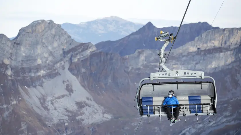 A skier wearing a medical face mask takes the 'Ice Flyer' chairlift on the Titlis, 10 November 2020, in Switzerland (issued 11 November 2020). Masks must be worn on all chairlifts, ski lifts and cableways in the ski area at times of Covid-19, Coronavirus pandemic. ANSA/ALEXANDRA WEY