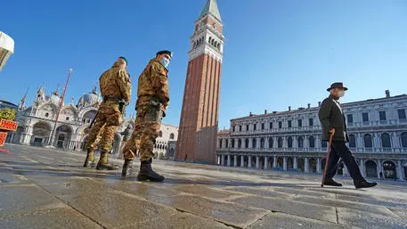Two soldiers on patrol and a passer-by are seen in San Marco Square, Venice, Italy, 13 January 2021. Due to the crisis in the tourism sector, following the Coronavirus health emergency, many historic shops have lowered their shutters permanently. ANSA/ ANDREA MEROLA