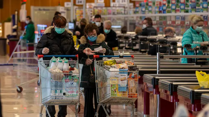 Due clienti che indossano mascherine sanitarie spingoni i carrelli della spesa dopo aver effettuato acqusiti all’Esselunga di viale Adriano, 24 Marzo 2020. ANSA/Marco Ottico