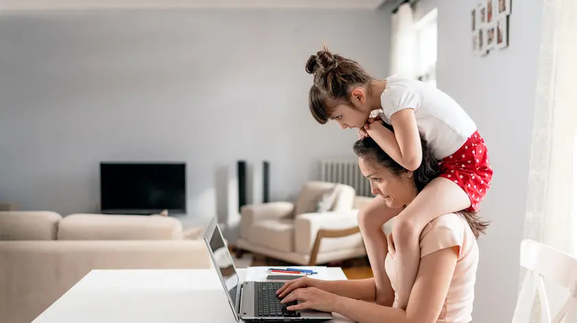 Una foto simbolo delle mamme lavoratrici (Ansa)